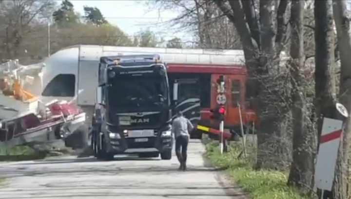 Поезд снес фуру с катером, вставшую на железнодорожном переезде в Норвегии. Видео